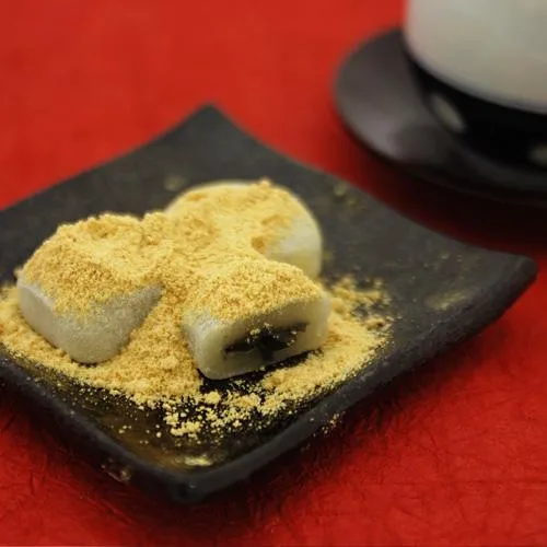 Close-up of Naniwaya Japanese Black Sesame Kinako Mochi (8 Pieces), 8 pieces, featuring black sesame center for rich taste.